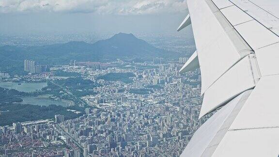 飞机低空飞行从飞机窗口俯瞰城市的