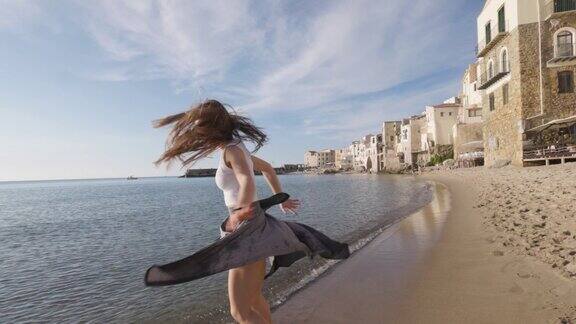 十几岁的女孩在Cefalu古镇的海滩上跳舞