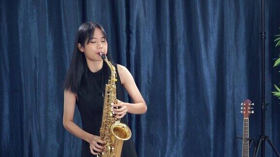 亚洲少女音乐家演奏独奏萨克斯管在音乐学校的课堂练习