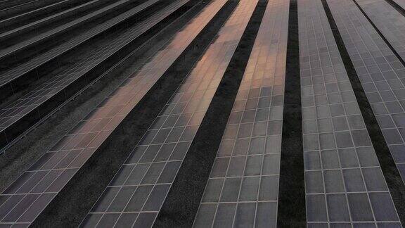 日落时太阳能发电厂的鸟瞰图阳光反射在太阳能电池板上