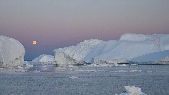 乘船到格陵兰岛满月出现在两座冰山之间