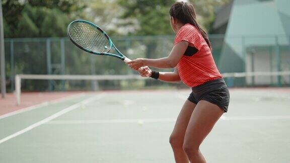 亚洲印度女网球运动员发球球在网球球场与教练指导在周末上午