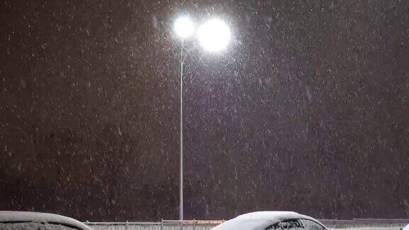 白雪皑皑的夜晚闪烁的街灯在马路上闪烁着过往的车辆