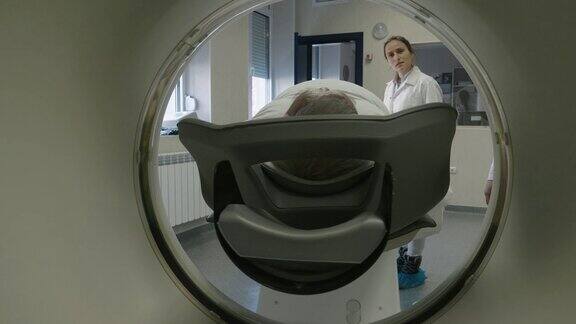 放射学家准备医用扫描仪工作与病人交谈并帮助他为手术做准备