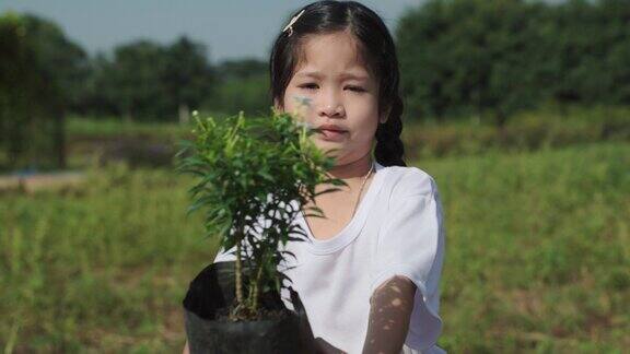 一位可爱的小女孩在丛林里植树栽培树苗志愿者与环境