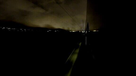 视角夜车疾驶火车到站和离开站台时间流逝夜间灯光反射在火车的窗户