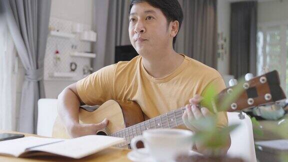 亚洲男子通过视频通话学习吉他