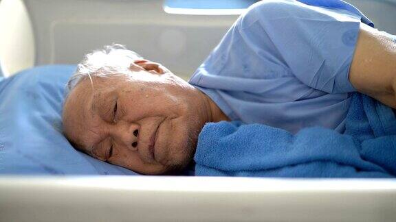 老年男性患者在医院病床上咳嗽