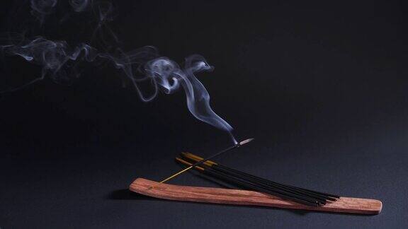 治疗东方烟香薰、放松和瑜伽香气棒的烟雾在4k的黑色背景上移动