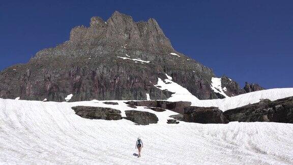 一名妇女在蒙大拿州的冰川国家公园洛根山口雪原上徒步旅行
