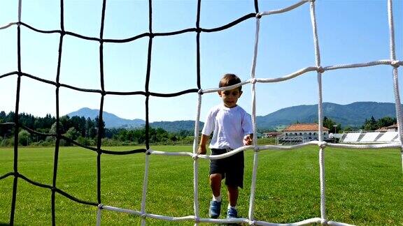 一个3岁小男孩在足球场上进球的跟踪摄像机