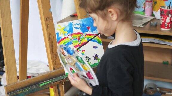 小女孩在画架画室画彩虹画