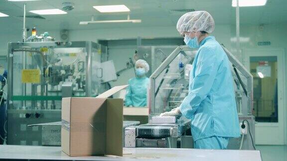 亚裔药剂师把药片装进盒子里在一个现代化的制药设施的药品生产线