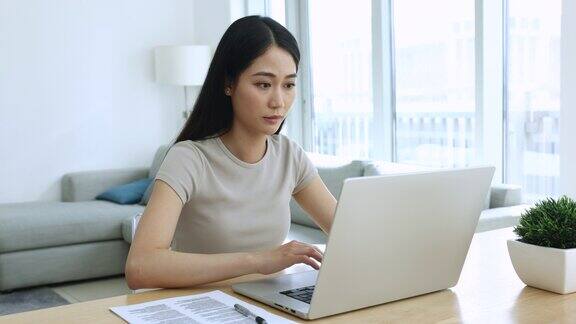 漂亮的亚洲女商人用笔记本电脑远程工作