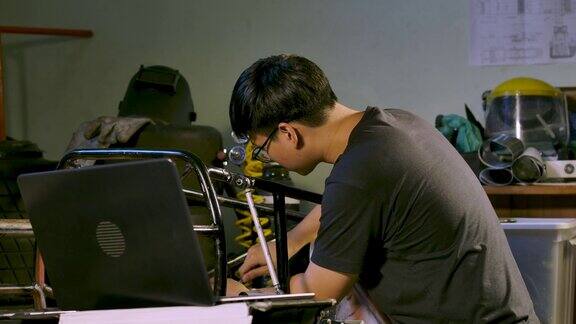 年轻的亚洲机械工程师在工作室车间工作技术与创新理念