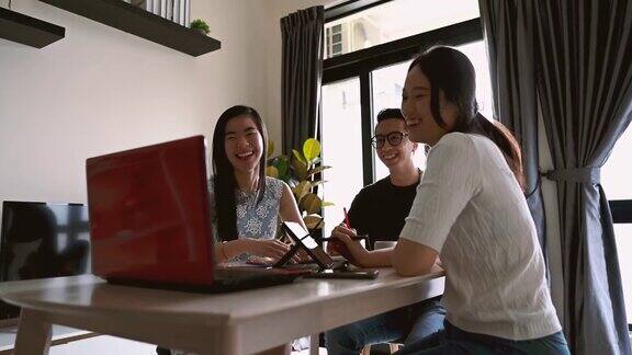 一群年轻的亚洲商人与他们的客户在办公室里进行视频会议