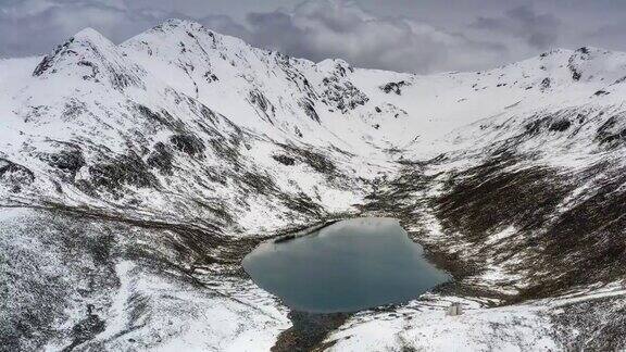 在一个阴天蓝色的湖躺在雪山的怀抱