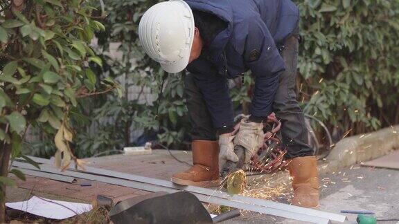 一名中年男性工人正在使用切割机和焊机