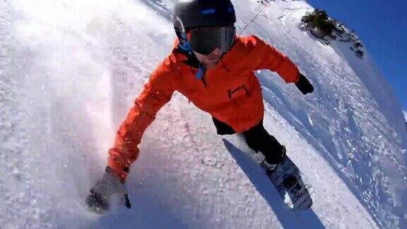 在一个阳光明媚的冬日一名男子在滑雪胜地的斜坡上雕刻