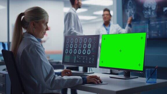 医院研究实验室:女性医学生物技术科学家工作在绿屏色度键计算机与脑扫描MRI图像背景:神经科学家开会分析核磁共振扫描