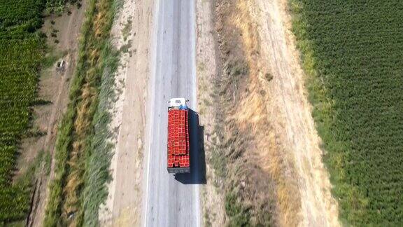满载西红柿的卡车在路上行驶鸟瞰图4K视频