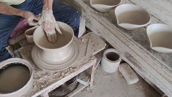 亚洲华人活跃的高级陶工工作在他的工作室与纺陶轮