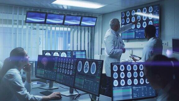 在大脑研究实验室工作的专业医学科学家团队神经学家神经科学家周围的显示器显示CTMRI扫描正在讨论和在个人电脑上工作