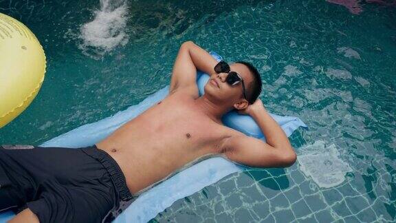 夏天年轻人在旅馆的游泳池里休息