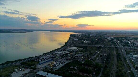 日落时分无人机飞过城市的一个湖泊