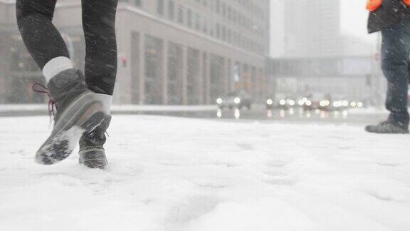 低角度拍摄的女人在城市的雪中行走