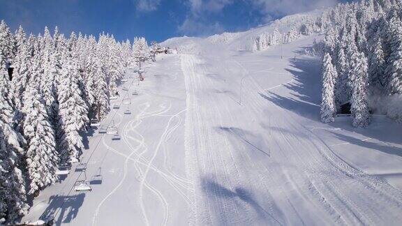 航拍:积雪覆盖的封闭滑雪场造雪机正在工作