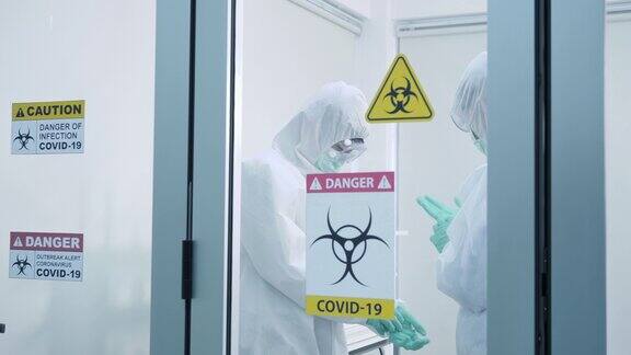 两位亚洲科学家穿着个人防护装备在实验室里