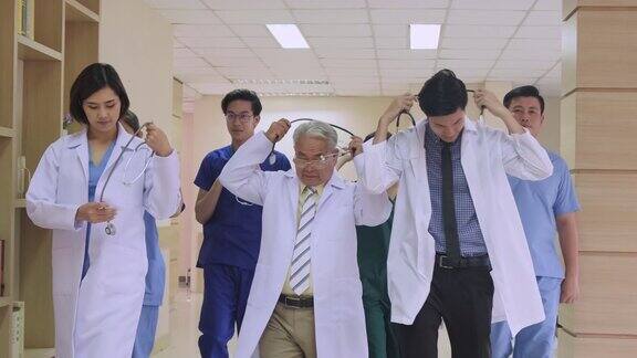 一组由医生、护士和助理组成的亚洲团队走过医院的走廊
