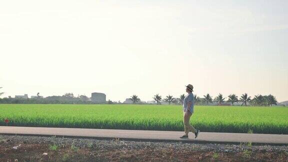 放松的亚洲中国妇女旅行在稻田边走在早上