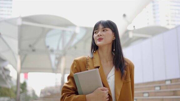 真实的肖像一个年轻成功的女商人站在办公大楼的背景业务人员美丽的亚洲年轻女孩快乐的微笑工作业务