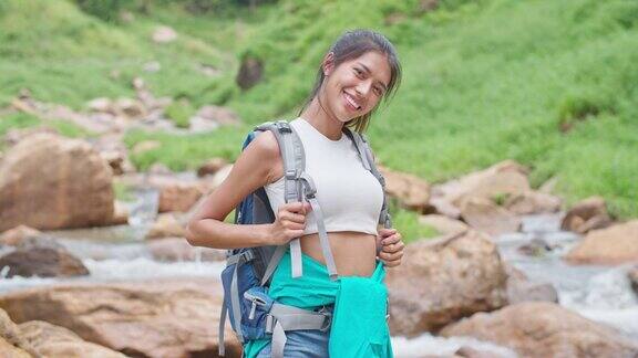 亚洲女徒步旅行者对着镜头微笑充满自信和快乐的情绪