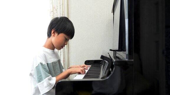 弹奏立式钢琴的日本男孩