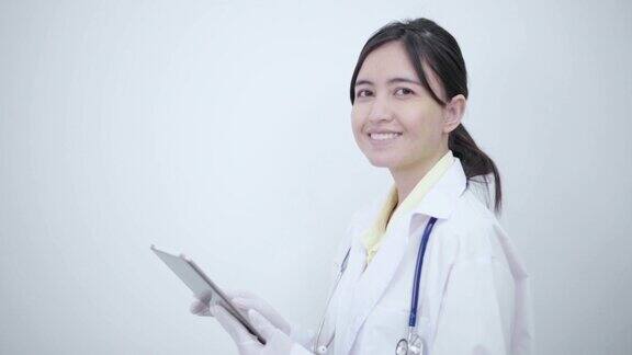 白袍女医生用平板电脑搜索一些疾病信息或阅读健康检查报告