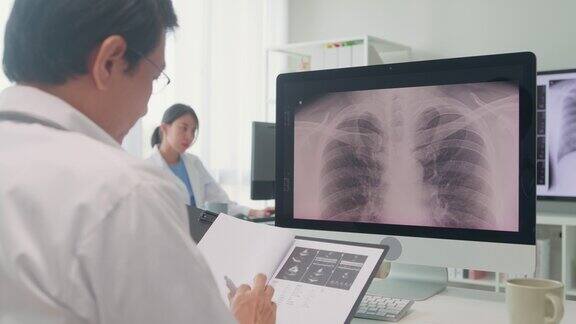 成年亚洲男医生在医院的电脑屏幕上检查病人的肺部x线图像医疗保健