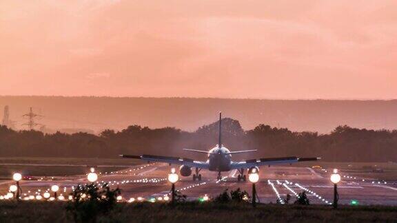 日落时飞机降落在机场跑道上