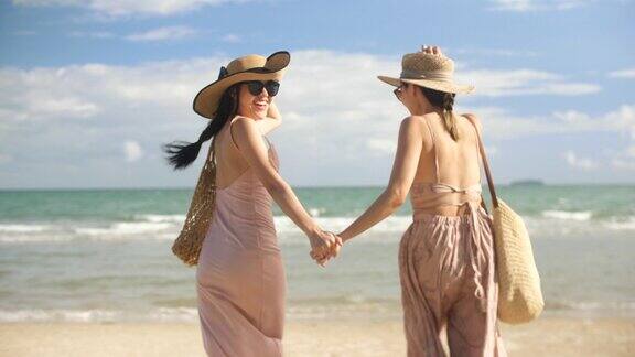 两个女人享受和快乐的跑步在海滩度假时间