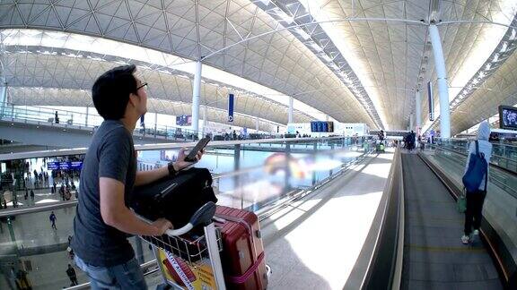 一名亚洲男子在机场用智能手机办理登机手续