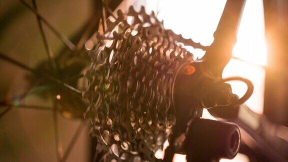 日落时旋转的变速器齿轮和自行车车轮辐条的细节