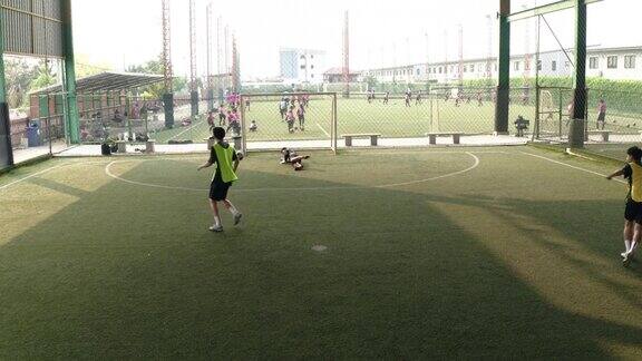 无人机拍摄:亚洲男子足球运动员和朋友打球