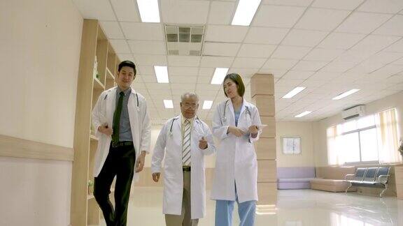 一群亚洲男女医生拿着听诊器和平板走路谈论医院里的病人主治医生向医生提供建议医疗保健