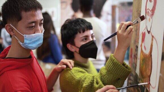 多种族学生戴着安全口罩在美术室上课画画