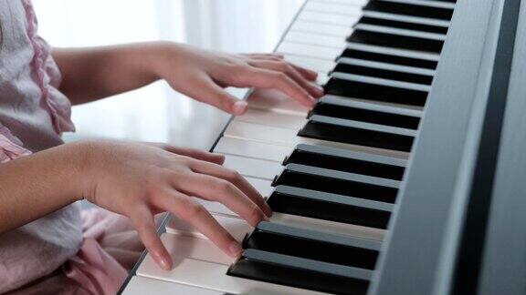 小女孩弹钢琴的慢镜头手的近景