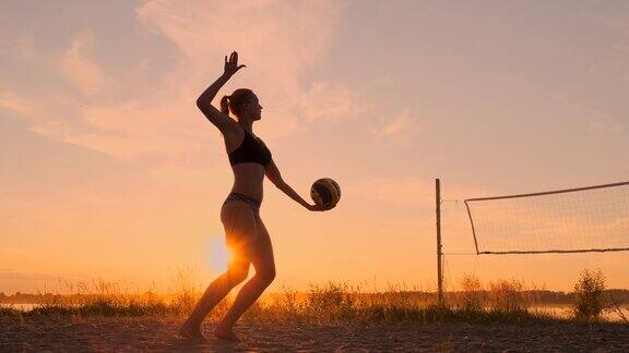 小女孩在沙滩上跳发球打排球动作缓慢