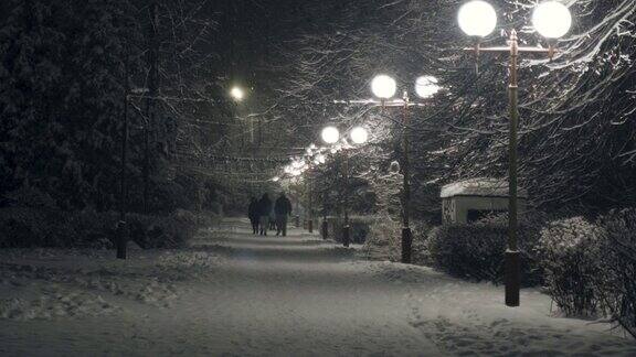 城市公园里下雪了人们在公园里散步