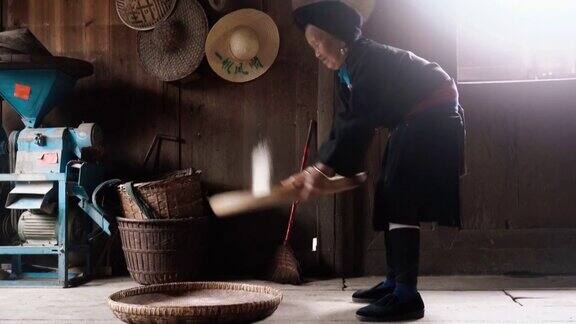 老少数民族中国妇女在农村的房子里筛大米